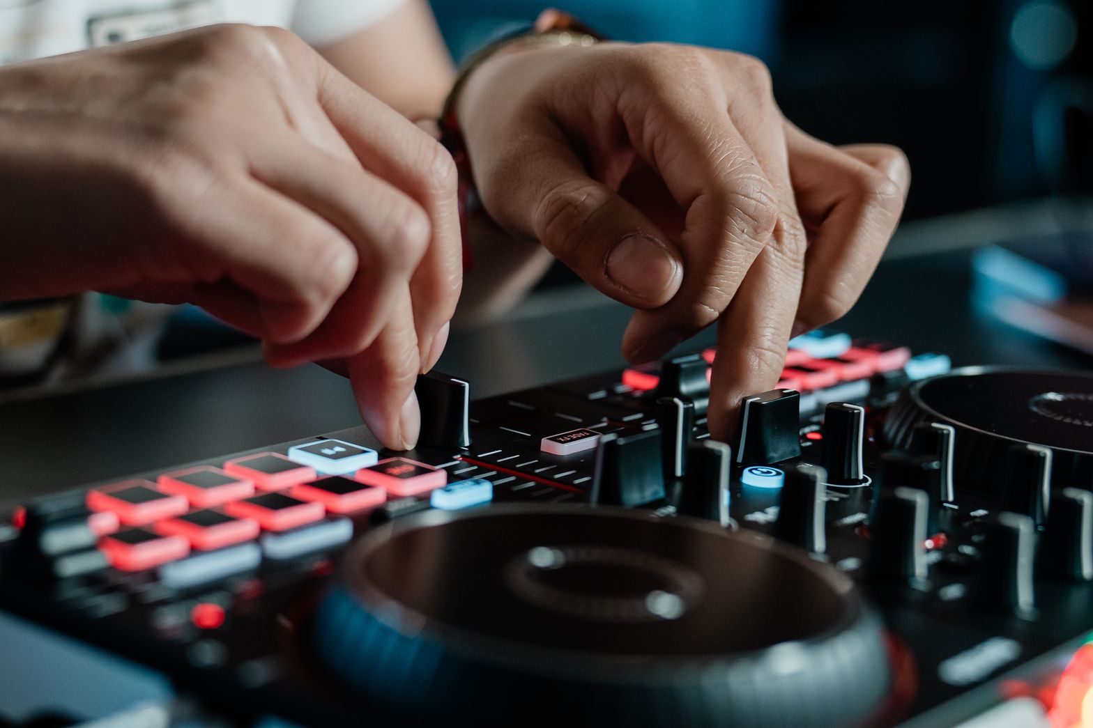 Party Mix III üzerinde performance pad ve crossfader kullanan DJ elleri yakın çekim